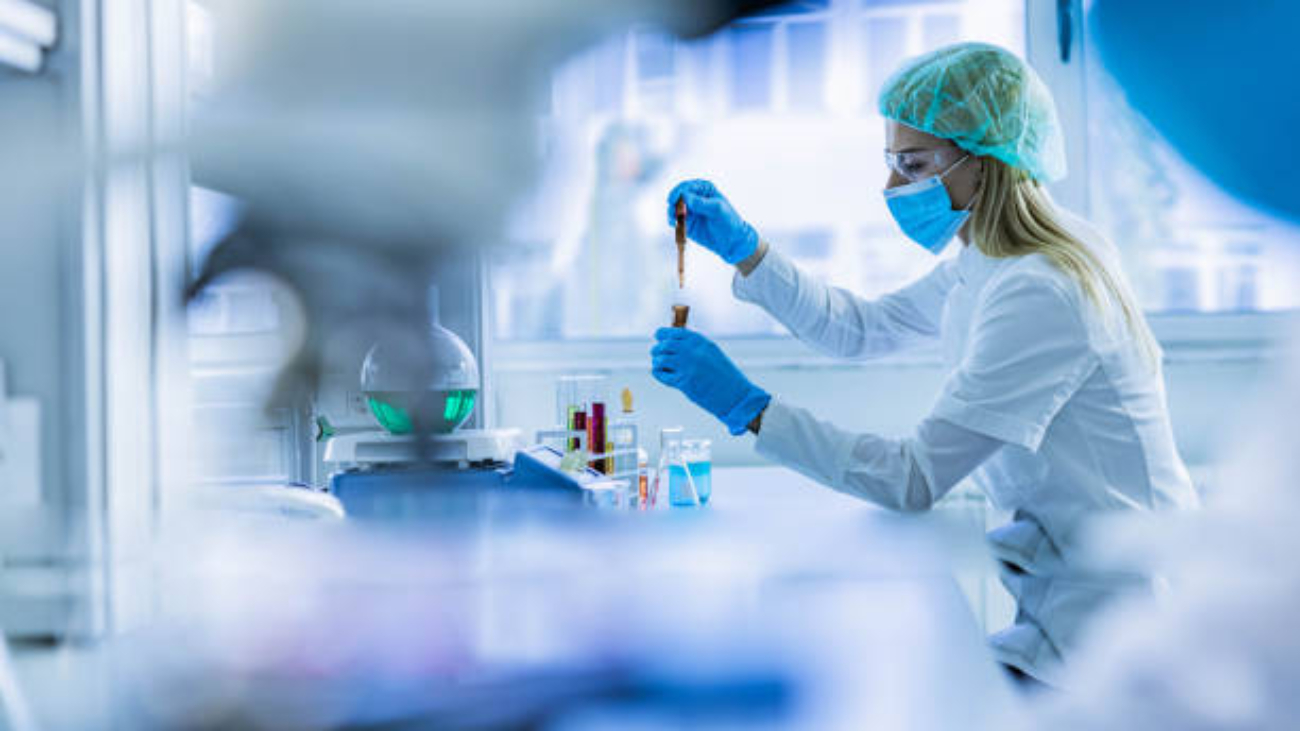 Young female chemist working with poisonous liquid in a laboratory.