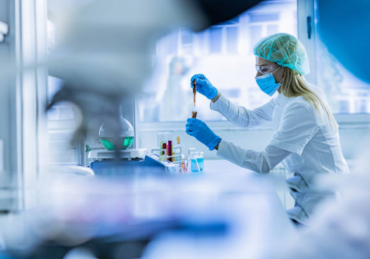 Young female chemist working with poisonous liquid in a laboratory.